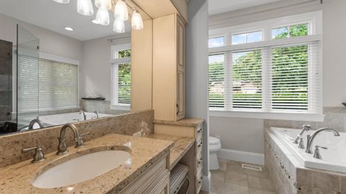 a bathroom with two sinks and a tub and a toilet at Making Waves by AvantStay Sleeps 20 Pool in Westport