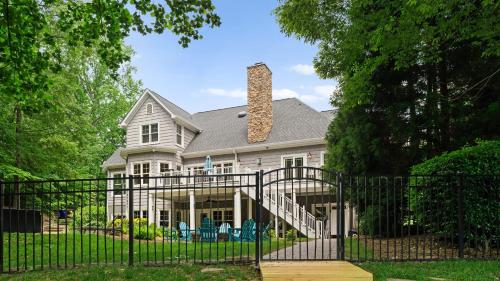 a white house with a black iron gate at Making Waves by AvantStay Sleeps 20 Pool in Westport