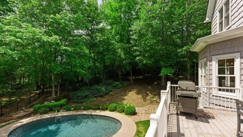 a backyard with a small swimming pool and a deck at Making Waves by AvantStay Sleeps 20 Pool in Westport