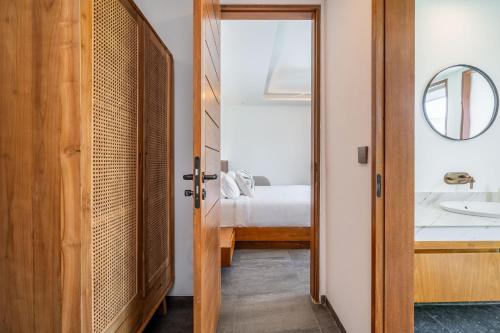 ein Badezimmer mit Waschbecken und ein Bett in einem Zimmer in der Unterkunft Villa Domus - B4 in Sanur