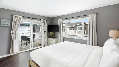 a bedroom with a bed and a large window at Topside Newport Rooftop Balcony Ocean Views Walk to Pier Marina Village in Newport Beach