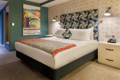 a bedroom with a large bed with a poster on the wall at Hilton Bournemouth in Bournemouth