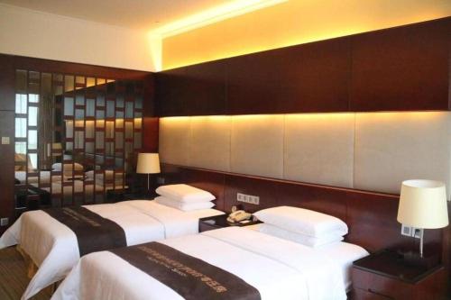a hotel room with two beds with white sheets at Grand Metropark Hotel Chongqing in Chongqing