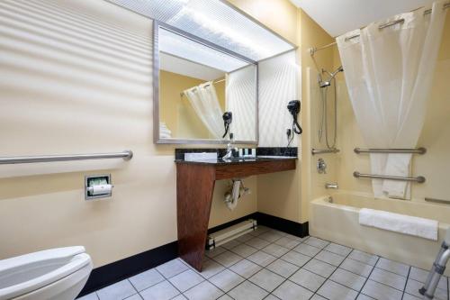 a bathroom with a toilet and a sink and a tub at Quality Inn Cheraw in Cheraw