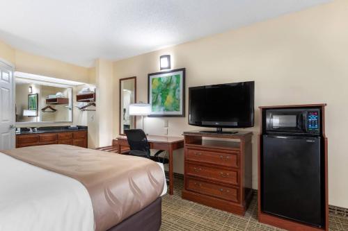 a hotel room with a bed and a flat screen tv at Quality Inn Cheraw in Cheraw