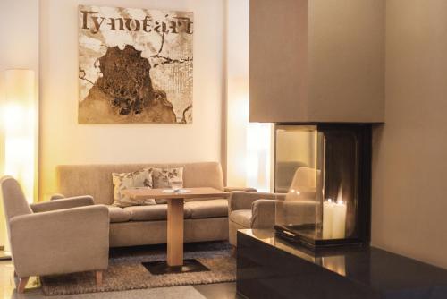 a living room with a couch and a fireplace at DAS VIER Sport,- und Wellnesshotel in Sankt Leonhard im Pitztal