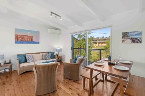 a living room with a table and a couch at Baxter's Beach House by Experience Jervis Bay in Vincentia