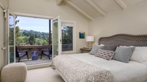 a bedroom with a large bed and a balcony at Chapman Cove by AvantStay Gorgeous Beach Bungalow w Sauna in Cannon Beach