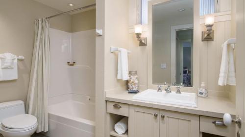 a bathroom with a sink and a toilet and a mirror at Chapman Cove by AvantStay Gorgeous Beach Bungalow w Sauna in Cannon Beach