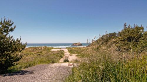 a dirt path leading to a beach with the ocean at Chapman Cove by AvantStay Gorgeous Beach Bungalow w Sauna in Cannon Beach