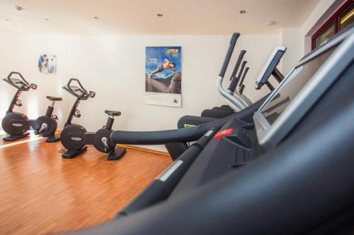 a gym with several tread machines in a room at DAS VIER Sport,- und Wellnesshotel in Sankt Leonhard im Pitztal