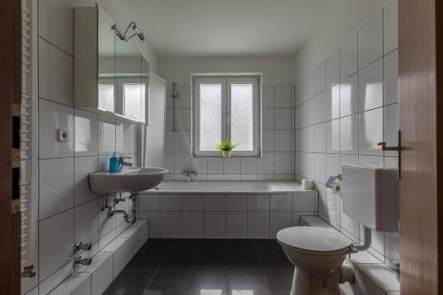 Un baño con bañera, inodoro y lavabo. en Ferienhäuser Bergfreiheit, en Winterberg