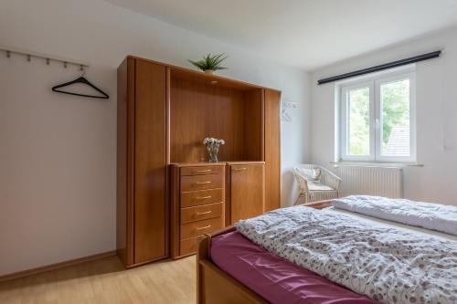 Un dormitorio con una cama y un armario de madera. en Ferienhäuser Bergfreiheit, en Winterberg