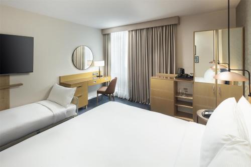 a hotel room with a bed and a desk at Hilton Garden Inn Birmingham Brindley Place in Birmingham