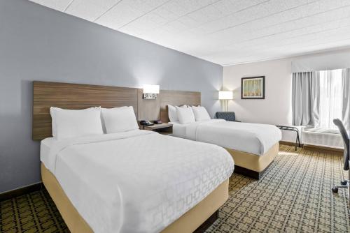 a hotel room with two beds and a window at Clarion Inn Cranberry Township in Cranberry Township