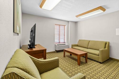 a living room with a couch and a tv at Clarion Inn Cranberry Township in Cranberry Township