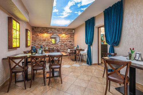 a dining room with blue curtains and a table and chairs at Old Tree Village & Restaurant in Oświęcim