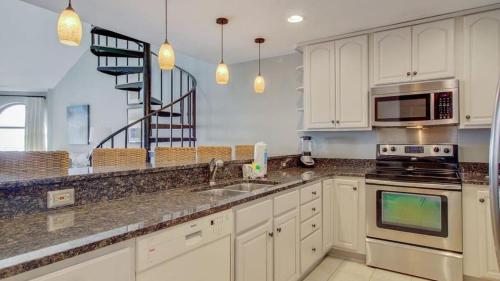 a kitchen with a sink and a stove top oven at 512 Seascape by AvantStay Oceanfront Condo on the Beach Community Pool Access in Isle of Palms