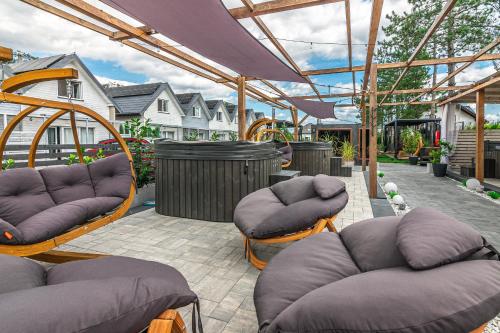 a patio with couches and chairs and a pergola at Old Tree Village & Restaurant in Oświęcim