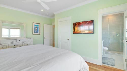 a white bedroom with a bed and a bathroom at 616 Carolina Boulevard by AvantStay Ocean Views from Decks in Mount Pleasant
