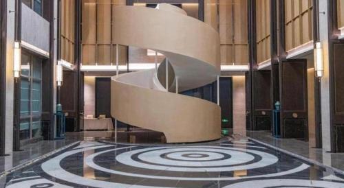 a lobby with a spiral staircase in a building at Dajiuhua Hotel in Chizhou