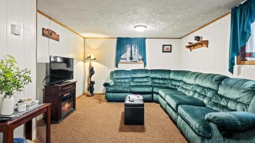 a living room with a green couch and a television at Mohegan by AvantStay Private Dock Firepit Community Pool Beach in Long Pond