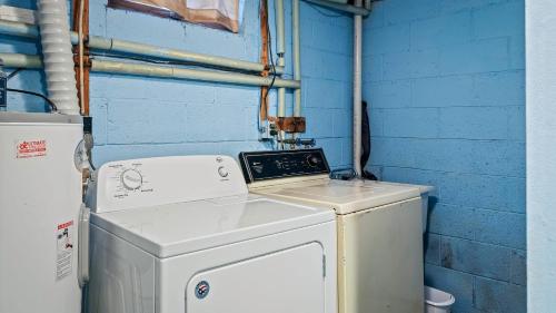 a laundry room with a washer and a blue wall at Mohegan by AvantStay Private Dock Firepit Community Pool Beach in Long Pond