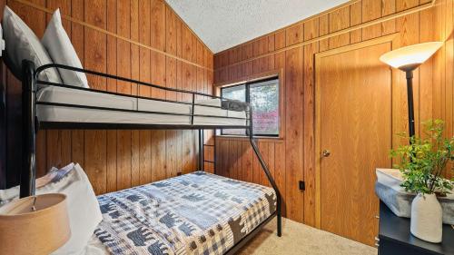 a bedroom with a bunk bed in a wooden wall at Mohegan by AvantStay Private Dock Firepit Community Pool Beach in Long Pond