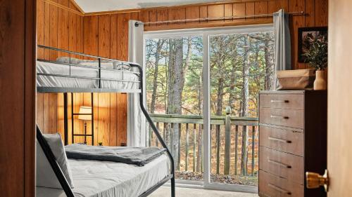 a bedroom with a bunk bed and a balcony at Mohegan by AvantStay Private Dock Firepit Community Pool Beach in Long Pond