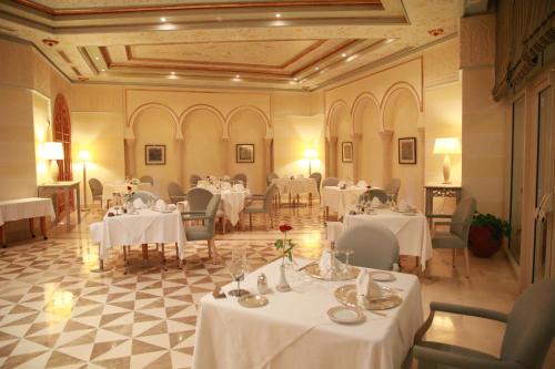 a dining room with tables and chairs with white tablecloths at Hasdrubal Prestige Thalassa & Spa Djerba in Triffa