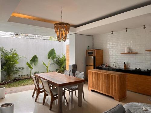 a kitchen and dining room with a wooden table at Mai Villa Umalas in Canggu