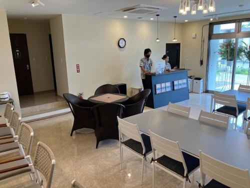 two people standing in a room with a table and chairs at HOTEL PAIKAJI - Vacation STAY 52773v in Ishigaki Island
