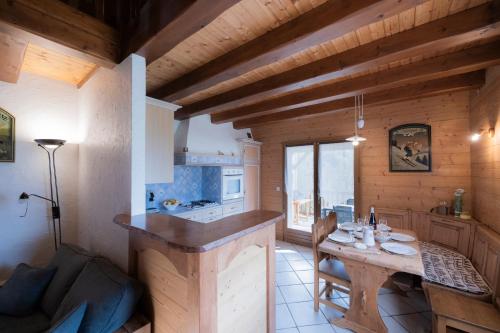 a kitchen and living room with a table in a cabin at Gîte La Clé Des Champs in Manigod