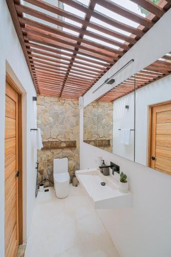 a bathroom with a toilet and a sink and a mirror at THE LOFT - Super Central General Luna in General Luna