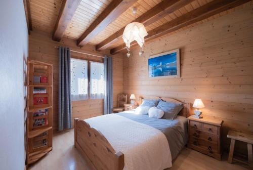 a bedroom with a bed in a wooden cabin at Gîte La Clé Des Champs in Manigod