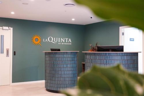 a company office with a sign on the wall at La Quinta by Wyndham Parnell Auckland in Auckland