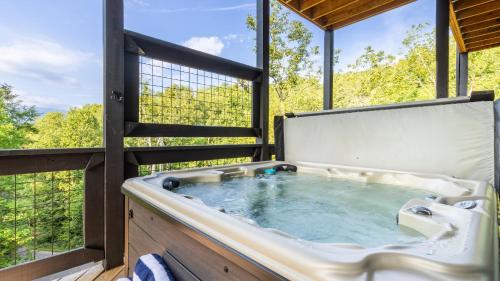 ガトリンバーグにあるRambling Ridge Lodge by AvantStay Endless Amenities Fun Indoor Pool Hot Tub A Arcade Game Roomの窓のある客室の中央にホットタブがあります。