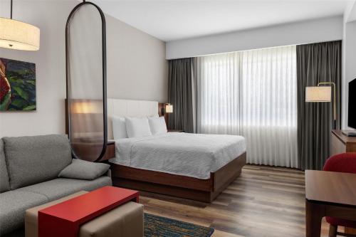 a hotel room with a bed and a couch at Homewood Suites By Hilton Cariari San Jose in San José