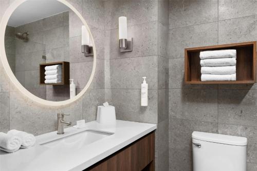 a bathroom with a sink and a mirror at Homewood Suites By Hilton Cariari San Jose in San José