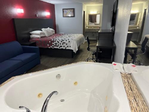 a hotel room with a bath tub and a bed at Econo Lodge Airport in Norfolk