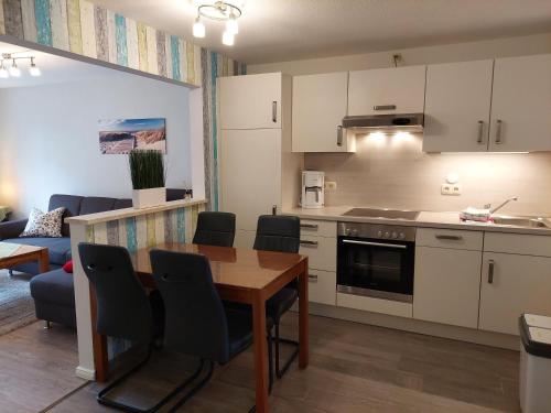 Una cocina y una sala de estar con mesa y sillas. en Ferienhof Friedenshof Hafer, en Vollerwiek