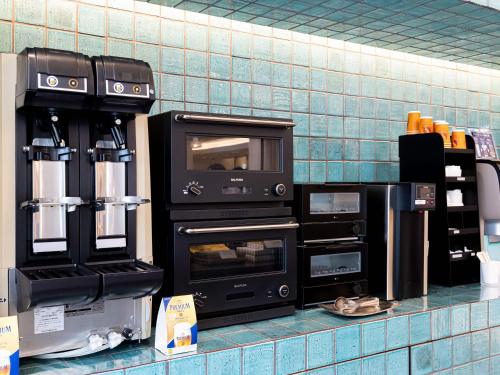 a kitchen counter with two ovens on a wall at Prince Smart Inn Nagoya Sakae in Nagoya