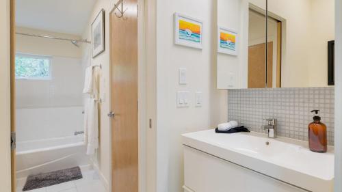 a white bathroom with a sink and a tub at Woodland Zen by AvantStay Modern Design Patio in Stockbridge