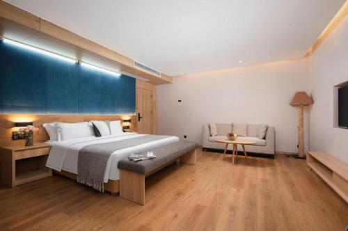 a hotel room with a large bed and a couch at New Beacon Sunyee SPA Hotel in Wuhan