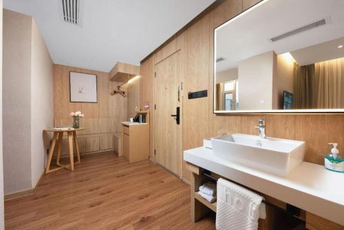a bathroom with a sink and a large mirror at New Beacon Sunyee SPA Hotel in Wuhan