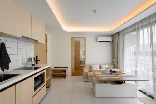 a kitchen and living room with a table and a couch at Kamala - 5 Min to Beach - Family Stay with 2 Baths in Kamala Beach