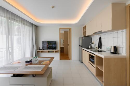 カマラビーチにあるFantasea Condo Kamala B204 2BDRM by Phuket Sabay Rentのテーブルとカウンタートップのあるキッチン