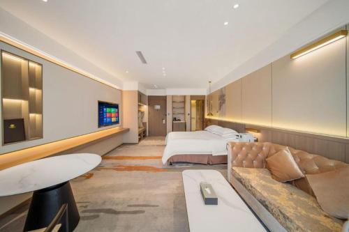 a hotel room with a bed and a couch at Northwest Petroleum Hotel in Ürümqi