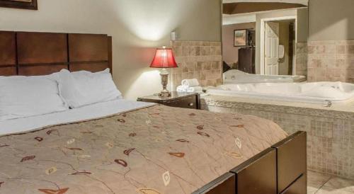 a bedroom with a large bed and a bath tub at Rodeway Inn Allentown South in Allentown