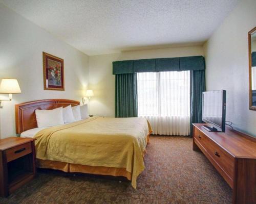 a hotel room with a bed and a television at Quality Inn & Suites Airport in Austin